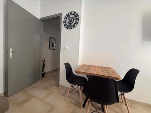 a dining room with a table and two black chairs at Sea Opera A4 in Kamena Vourla