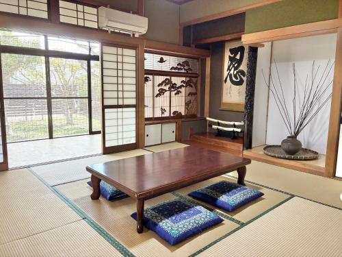 a living room with a table and some windows at さつき邸 -Satsuki House- in Fukuoka