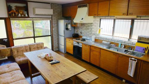 a kitchen with wooden cabinets and a wooden table at さつき邸 -Satsuki House- in Fukuoka