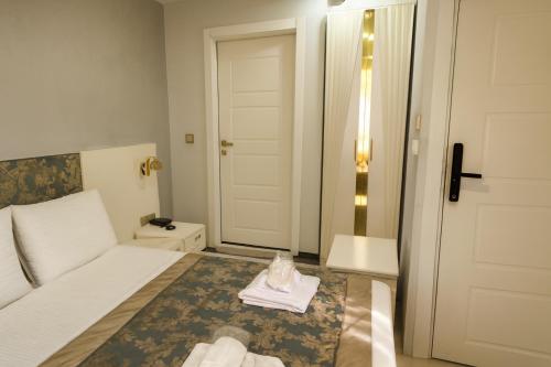 a hotel room with a bed and a door with towels at Şiva Pera Hotel & Spa in Istanbul