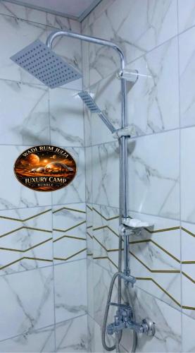 a shower in a bathroom with a sign on the wall at WADI RUM JULIA lUXURY CAMP in Wadi Rum