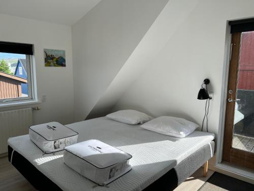 a bedroom with a bed with two boxes on it at Penthouse Apartment with Balcony in City Centre and Private Parking in Tórshavn