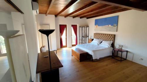 a bedroom with a white bed and wooden floors at Donna Maria Ludovica in Pescia Romana