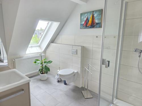 a white bathroom with a toilet and a shower at Ferienwohnung Rückerts Gartenblick in Nordhausen
