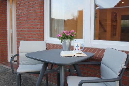 a table and chairs on a patio with a window at Ferienwohnung "Lüttje Koje" in Barßel