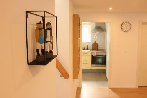 a kitchen with a clock on the wall and a mirror at Ferienwohnung "Lüttje Koje" in Barßel