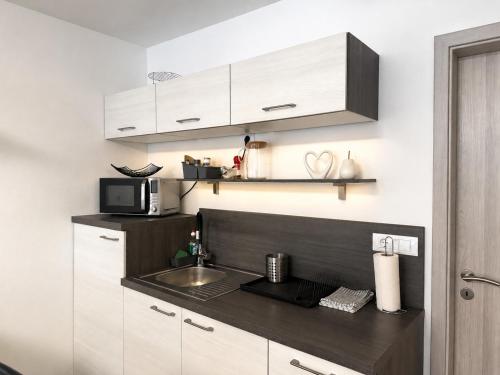 a kitchen with a sink and a microwave at Apartma Lilly in Bohinjska Bela