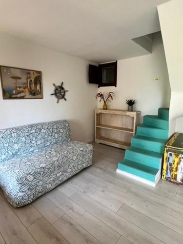 a living room with a couch and a staircase at Casa Merella in Narbolia