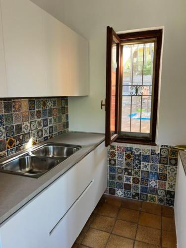 a kitchen with a sink and a window at Casa Merella in Narbolia