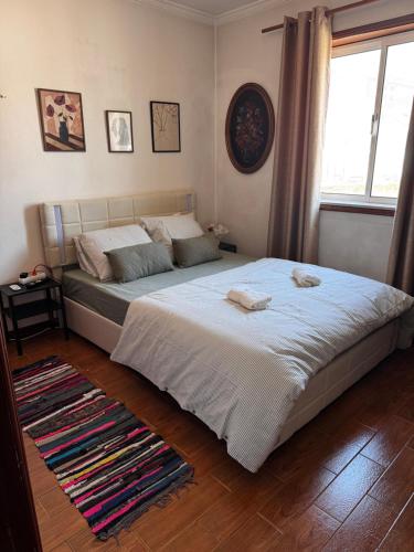 a bedroom with a large bed and a window at The Travellers Den in Matosinhos