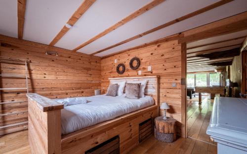 a bedroom with a bed in a log cabin at Les Gîtes de Sprimont - Le Cottage in Sprimont