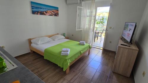 a bedroom with a bed with a green blanket at Apartmani Darijo in Čelina