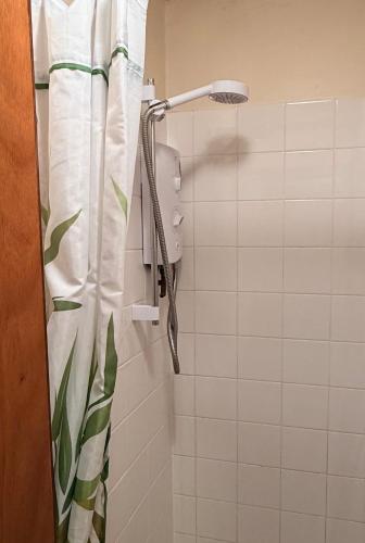 a shower with a shower head in a bathroom at Newtonmore Hostel in Newtonmore