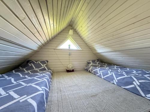a attic bedroom with two beds and a window at Diby Kämping Minimajad in Vormsi