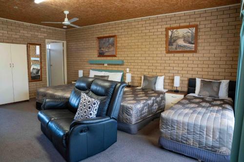 a bedroom with a couch and a bed and a chair at Sunrise Motel in Barooga