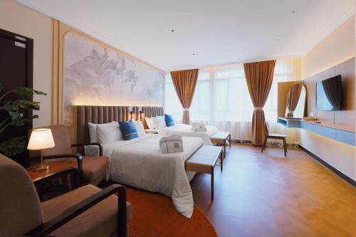 a large hotel room with two beds and a couch at Hotel Sixty3 in Kota Kinabalu