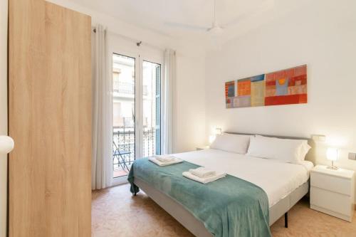 a white bedroom with a bed and a window at Charming central gem in Poble Sec in Barcelona