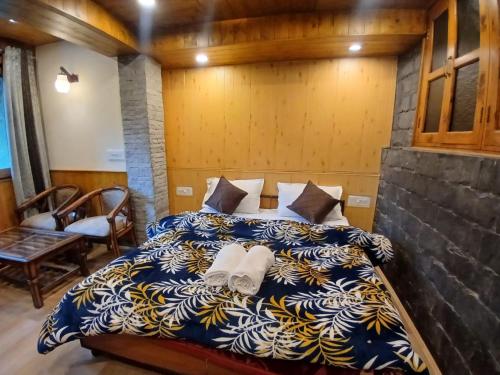 ein Schlafzimmer mit einem Bett, auf dem zwei Handtücher liegen in der Unterkunft Annantam in Manali