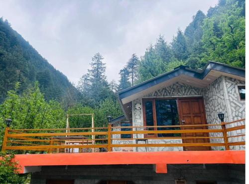 ein kleines Gebäude mit einer roten Bank davor in der Unterkunft Annantam in Manali