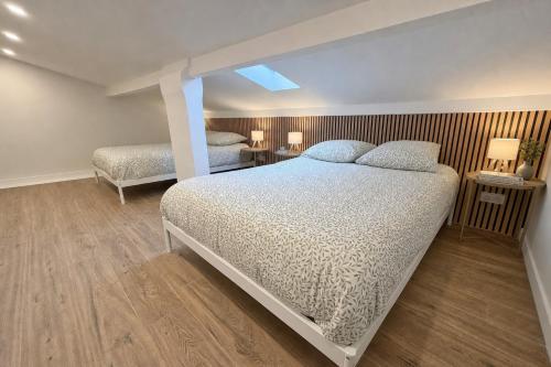a bedroom with two beds and two tables with lamps at L'Esterel Appartements Plage 450m & Gare Saint-Raphael 950m in Fréjus