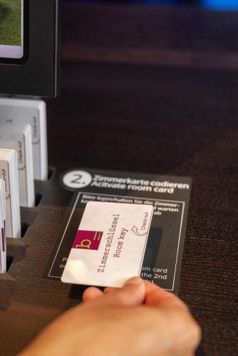 a person holding a card on a nintendo wii controller at b-smart hotel Bendern in Bendern