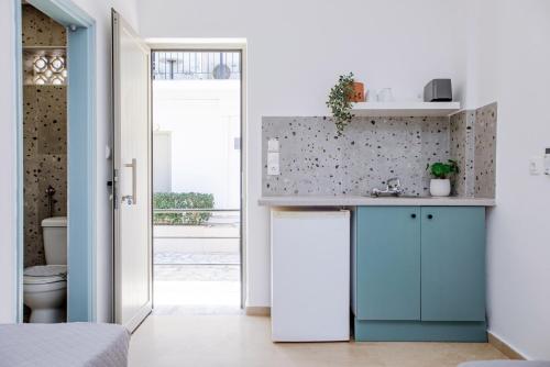 a kitchen with a blue cabinet and a toilet at Seaside Resorts in Kavos