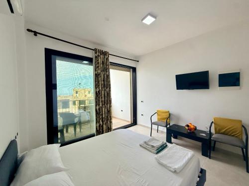 a bedroom with a bed and a large window at Actium in Vlorë