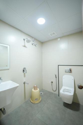 a bathroom with a toilet and a sink at Sri Sai Lotus In in Bangalore