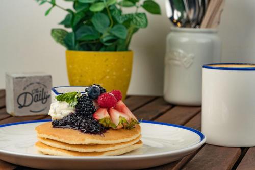 a plate of pancakes with fruit on a table at Rove Expo City in Dubai