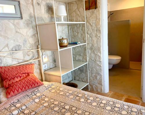 a bedroom with a bed and a bathroom with a toilet at Unique Robinson-House with breathtaking seaview in Podšpilje