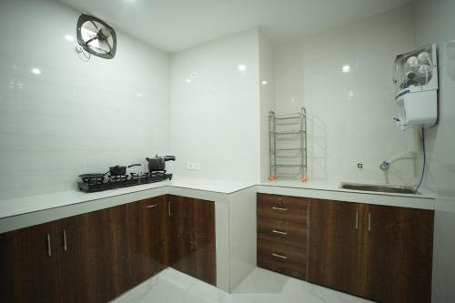 a kitchen with wooden cabinets and a stove in it at Hotel Parkview in Khajurāho
