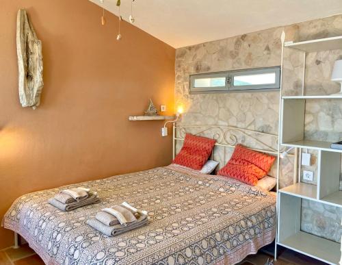 a bedroom with a bed with two pillows on it at Unique Robinson-House with breathtaking seaview in Podšpilje