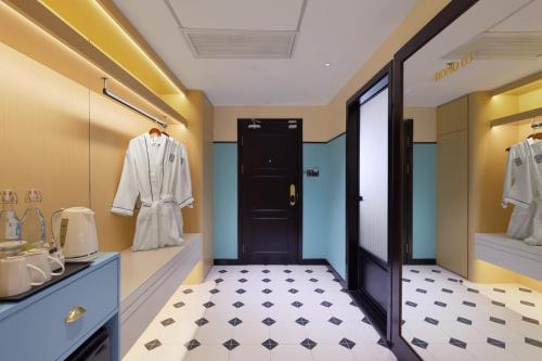 a bathroom with a black door and white tile floor at Hotel Sixty3 in Kota Kinabalu