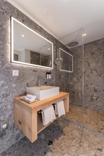 a bathroom with a sink and a mirror at Hotel Donatz in Samedan
