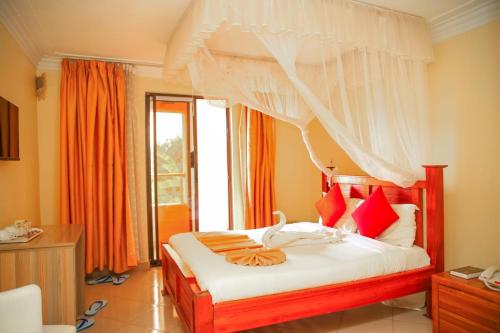 a bedroom with a large bed with red pillows at Grand Forty Garden Ltd in Kisumu