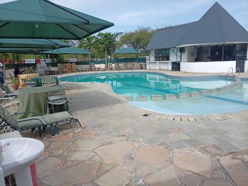 a large swimming pool with a table and chairs at Grand Forty Garden Ltd in Kisumu