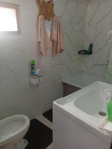 a white bathroom with a sink and a toilet at Guest House Aruuke in Naryn