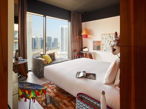 a hotel room with a large bed and a large window at Mama Shelter Dubai in Dubai