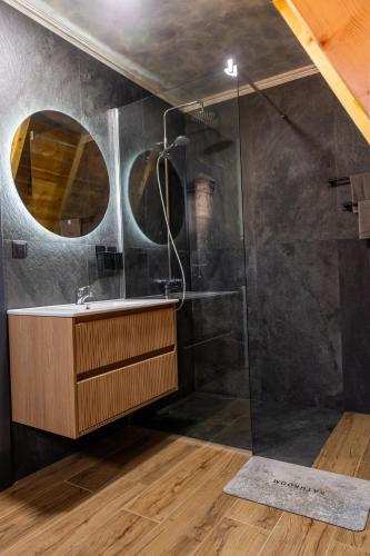 a bathroom with a shower with a sink and a mirror at Falcon View Zabljak in Žabljak