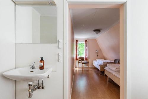 a bathroom with a sink and a bed in a room at Kanalvillan Dalsland in Dals Långed