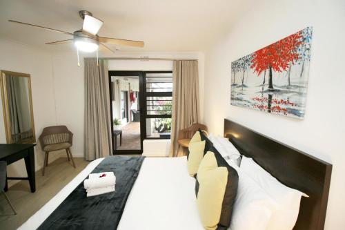 a bedroom with a large bed with white sheets and pillows at Woodbridge Lodge in Cape Town