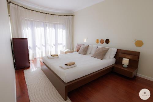 a bedroom with a large bed and a large window at Apartamento Ruy Belo - Foz in Vila do Conde