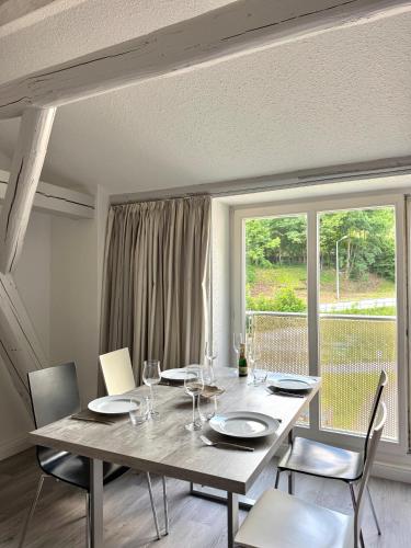 a dining room with a table and chairs and a window at Brauhaus Suite 20 in Sebnitz