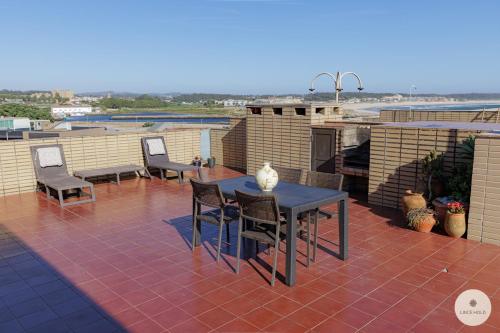 a patio with a table and chairs on a roof at Apartamento Ruy Belo - Foz in Vila do Conde