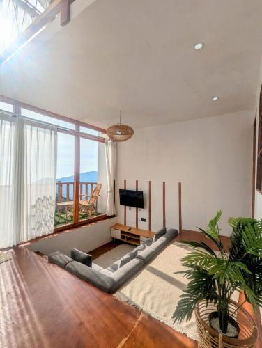a living room with a couch and a television at Tribuana villa Dieng in Kejajar