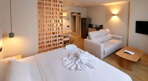 a living room with a white bed and a chair at Alcudia Boutique Apartments in Alcudia