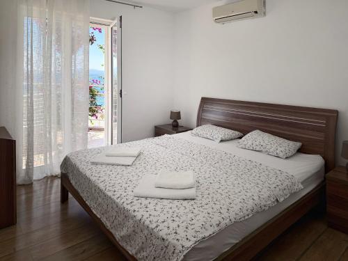 a bedroom with a bed with two towels on it at Apartment Orange Blossom First Line & Pool 1 in Bijela