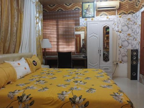 a bedroom with a yellow bed and a desk at A & J Services in Tesa