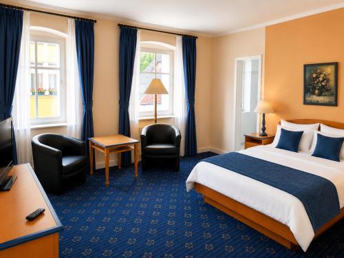 a hotel room with a bed and a television at Hotel zum Felsenkeller Oybin in Oybin