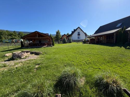a grassy yard with a house and a barn at Osada Karkonoska in Kowary